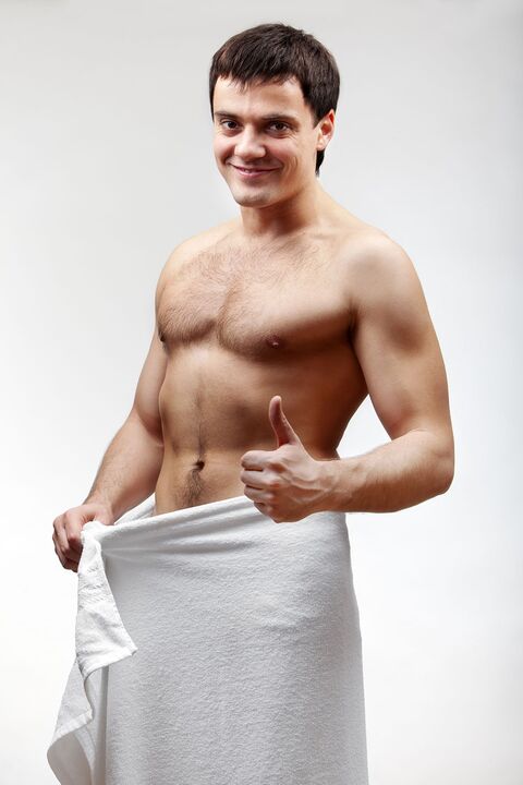 a man in a towel is happy with the increased size of his penis