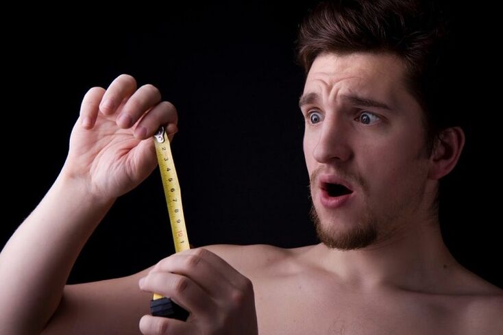 a man with a tape measure measured his penis before an enlargement operation